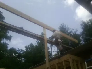 Carpenter setting a ridge beam over a new addition frame — Ice Dam Removal by Roofing Brothers in Corrales