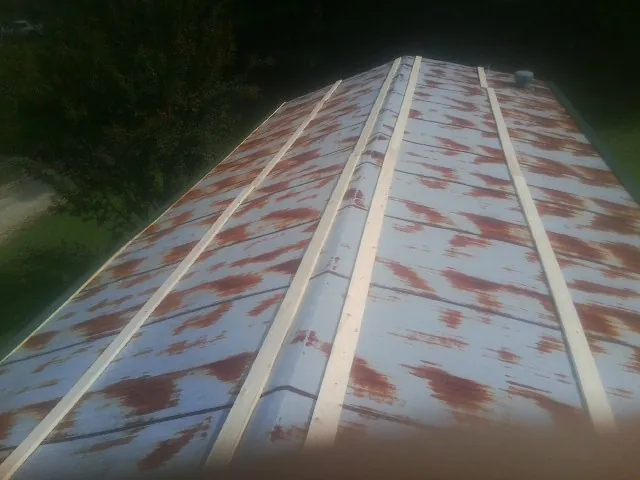Rusted metal roof panels with new wood purlins before replacement — Storm Damage Roof Repair in Corrales by Roofing Brothers