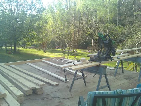 Miter saw and framing lumber on a deck under construction in Corrales