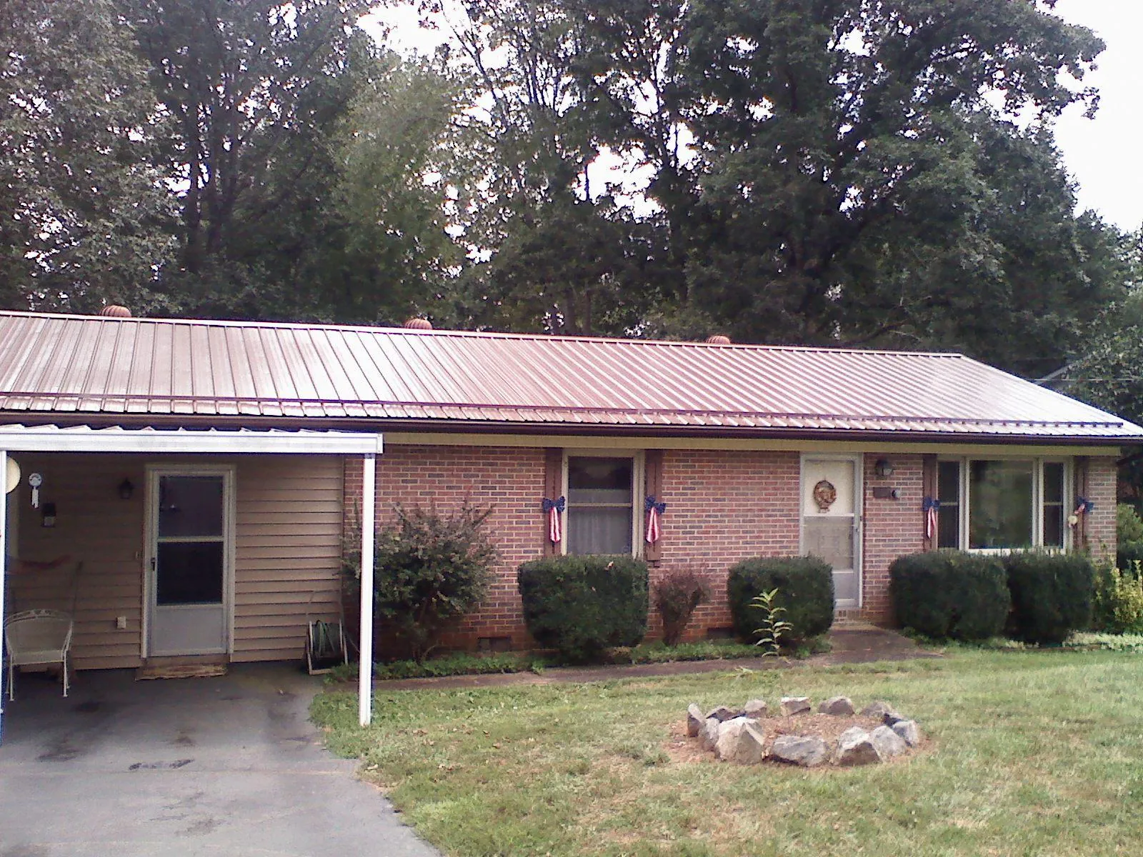 Bronze metal roof and carport on a brick ranch home — Roof Repair work by our crew in Corrales